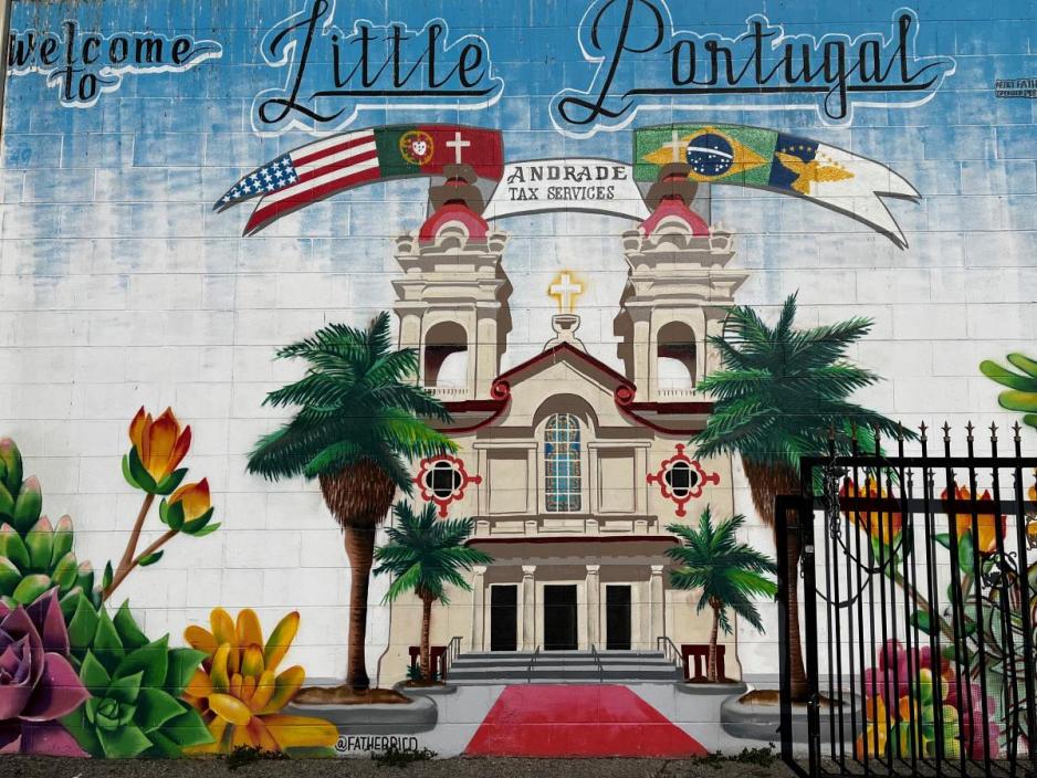 A wall with a mural of a church and trees