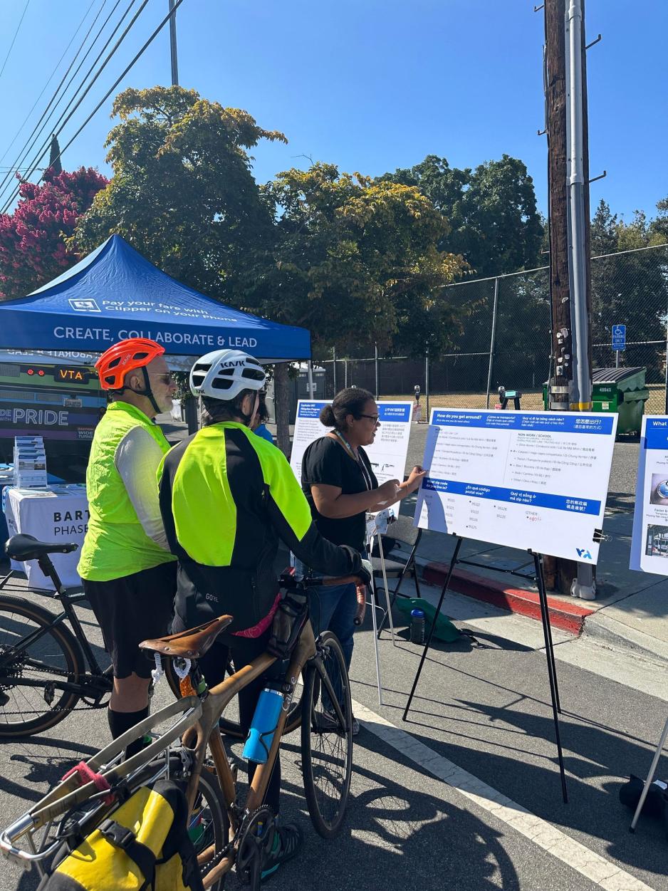 bicyclists looking at display board